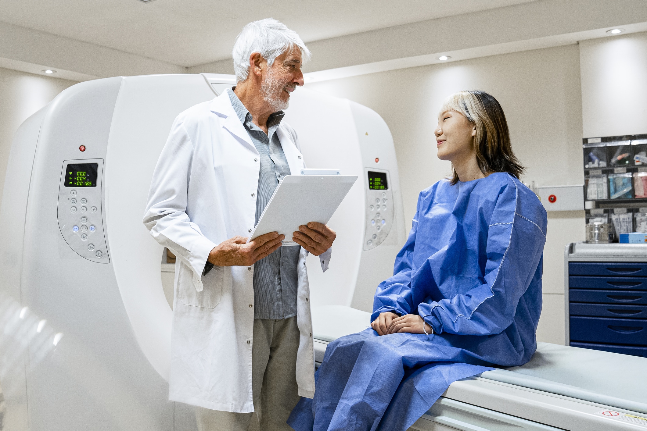 male doctor talking to patient sitting on a ct scanner